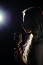 Silhouette of the singer with a microphone on dark background Royalty Free Stock Photo