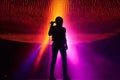 Silhouette of a singer on stage with a colorful light show in the background. Generative AI Royalty Free Stock Photo