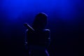 Silhouette of singer on stage. Dark background, smoke, spotlights.