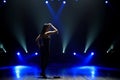 Silhouette of singer standing on stage at microphone in night club. Royalty Free Stock Photo