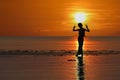 Silhouette of single Asian girl enjoying herself during sunset on the beach red sky Royalty Free Stock Photo