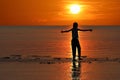 Silhouette of single Asian girl enjoying herself during sunset on the beach red sky Royalty Free Stock Photo