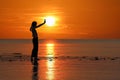 Silhouette of single Asian girl enjoying herself during sunset on the beach red sky Royalty Free Stock Photo