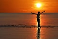 Silhouette of single Asian girl enjoying herself during sunset on the beach red sky Royalty Free Stock Photo