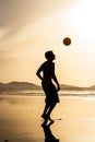 Silhouette of a man playing football soccer at sunset. Famara beach, Lanzarote, Canary Islands, Spain.