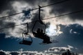 Silhouette of skiers sitting on ski-lift chairs