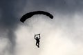 A silhouette of a skydiver performing skydiving with parachute