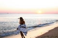 The silhouette of a slender tanned blonde walks along the ocean Royalty Free Stock Photo