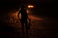 Silhouette of a slender young woman with violin in car headlights illumination Royalty Free Stock Photo