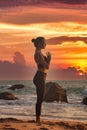 Silhouette slim woman does yoga on tropical sea coast or ocean beach outdoors at sunset Royalty Free Stock Photo