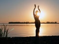 Silhouette of slim woman with hands up in the air illuminated with sunshine dancing traditional tribal belly dance Royalty Free Stock Photo