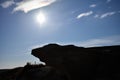 A silhouette of a small cliff edge hovers over a nature path.