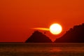 Silhouette of small island with mountains in sunset or sunrise sky over sea, Sun setting over the ocean beautiful light nature Royalty Free Stock Photo