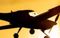 Silhouette of small propeller plane landing or taking off on the runway of Sabadell airport with a totally orange sky Royalty Free Stock Photo