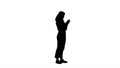 Silhouette Smiling casual woman holding smartphone using it.