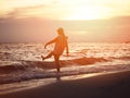 Silhouette smiling woman kicking water wave on the beach Royalty Free Stock Photo