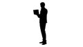 Silhouette Smiling young businessman using laptop while standing