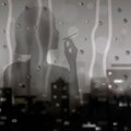 Silhouette of a smoking girl in the window with raindrops on the background of the cityscaperain. drops on glass with blurry Royalty Free Stock Photo