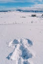 Silhouette of a snow angel on a sunny snowy plain in a mountain valley Royalty Free Stock Photo