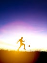 Silhouette of soccer player kicks ball