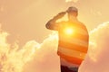 Silhouette of soldier with print of sunset and USA flag saluting on a background of light sky. Royalty Free Stock Photo