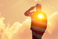 Silhouette of soldier with print of sunset and USA flag saluting on a background of light sky. Royalty Free Stock Photo