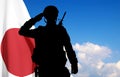 Silhouette of a soldier saluting on background of sky with Japan flag