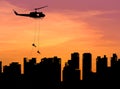 silhouette soldiers in action rappelling climb down from helicopter in building skyscraper on sunset Royalty Free Stock Photo