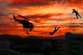 Silhouette Soldiers rappel down to attack from helicopter with sunset and copy space add text Concept stop hostilities To peace Royalty Free Stock Photo