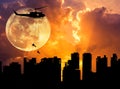 Silhouette soldiers rappelling from helicopter in skyscraper on sunset with full moon Royalty Free Stock Photo