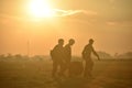 Silhouette of soldiers who help each other carry parachutes after skydiving