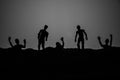 Silhouette some zombies on the cemetery walking around at sunset. Selective focus Royalty Free Stock Photo