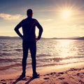 Silhouette of sport active adult man running and exercising on the beach. Calm water Royalty Free Stock Photo