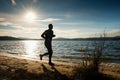 Silhouette of sport active man running and exercising on beach at busch below sunset. Royalty Free Stock Photo