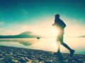 Silhouette of sport active man running on the lake beach at sunrise. Healthy lifestyle. Royalty Free Stock Photo