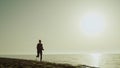 Silhouette sportswoman running seashore. Girl jogging sandy beach at sunset.