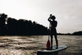 silhouette of sportswoman standing on paddleboard