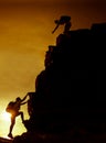 Silhouette sporty woman on the cliff with help