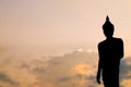 Silhouette of Stand Buddha against evening sky with copy space background