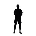 Silhouette of a standing man in shorts, hands behind his back.