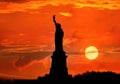 Silhouette of Statue of Liberty over dramatic sunset, New York, USA Royalty Free Stock Photo