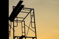 Silhouette of steel scaffolding with wooden plate at the construction site isolated on sunset sky. Day off Royalty Free Stock Photo