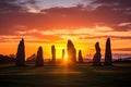 silhouette of a stone circle against a vivid sunset sky