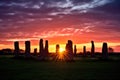 silhouette of a stone circle against a vivid sunset sky