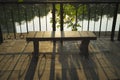 Silhouette stone park bench by lake at sunset