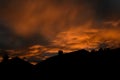 Silhouette of street of houses exterior in sunset with dark sky behind buildings