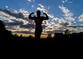 Silhouette of a strong muscular man on a background of sunset sky. Royalty Free Stock Photo