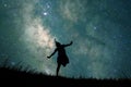 Silhouette of student girl running in glass fields and full of stars in the sky at night