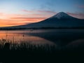 silhouette style from 25s to 35s man sit and wait for see sunrise from kawaguchi lake and fuji mountain background from japan Royalty Free Stock Photo