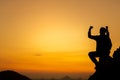 Silhouette of success man hiker outstretched arms on top of the mountain with beautiful sunset. Concept of traveling and hiking Royalty Free Stock Photo